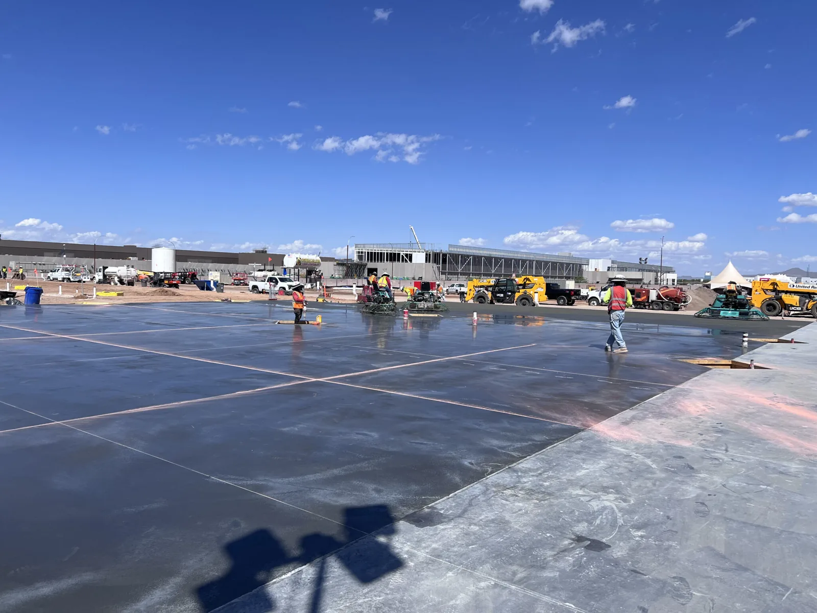 A large freshly poured concrete slab curing under the Phoenix sun